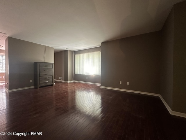 unfurnished bedroom with dark wood-type flooring and baseboards