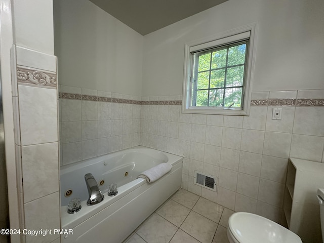 full bath featuring tile walls, visible vents, toilet, tile patterned flooring, and a tub with jets