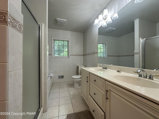 full bathroom featuring tile walls, a sink, visible vents, and tile patterned floors