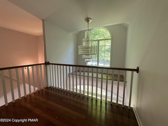 stairway with a notable chandelier and wood finished floors