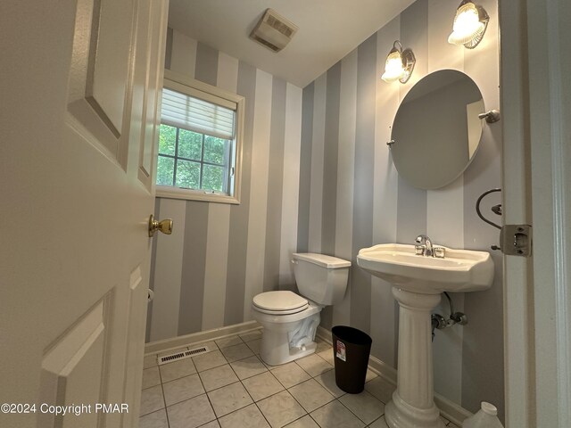 bathroom featuring toilet, baseboards, visible vents, and wallpapered walls