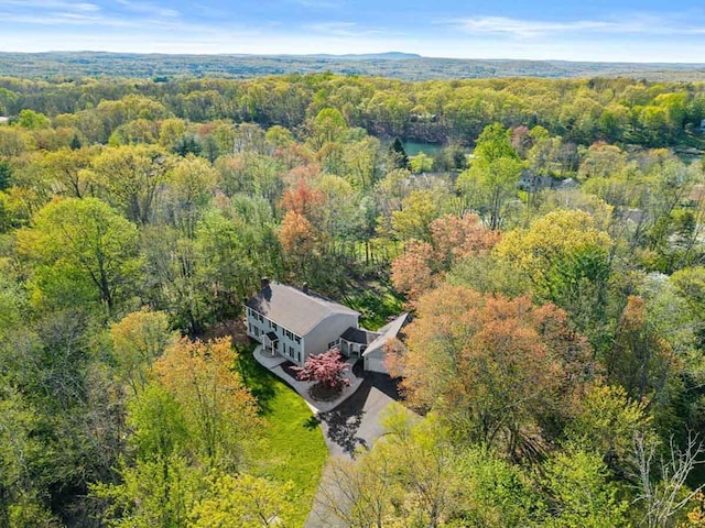 aerial view of property and surrounding area featuring a forest