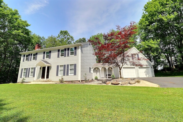 155 Kimberleigh Ct, East Stroudsburg, PA 18301 - colonial house with asphalt driveway, a chimney, a front lawn, and a garage
