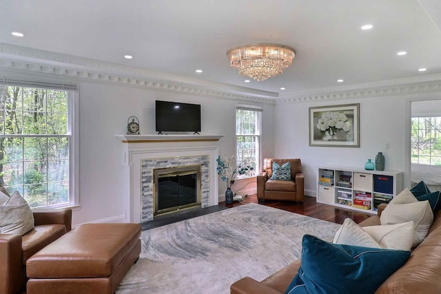 living room with healthy amount of natural light, recessed lighting, a chandelier, wood finished floors, and a stone fireplace