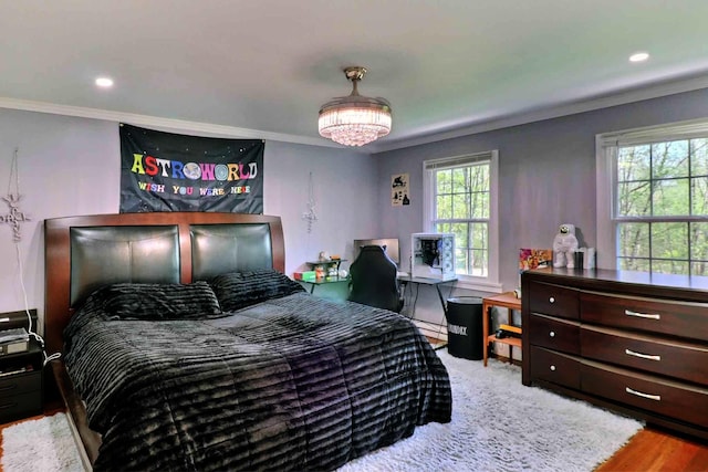 bedroom with crown molding, wood finished floors, and recessed lighting