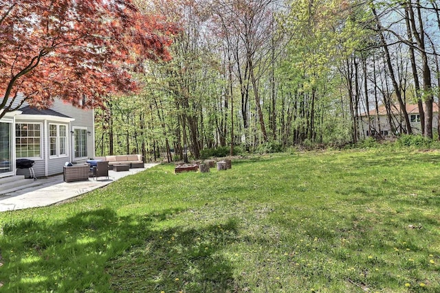 view of grassy yard with an outdoor living space and a patio area