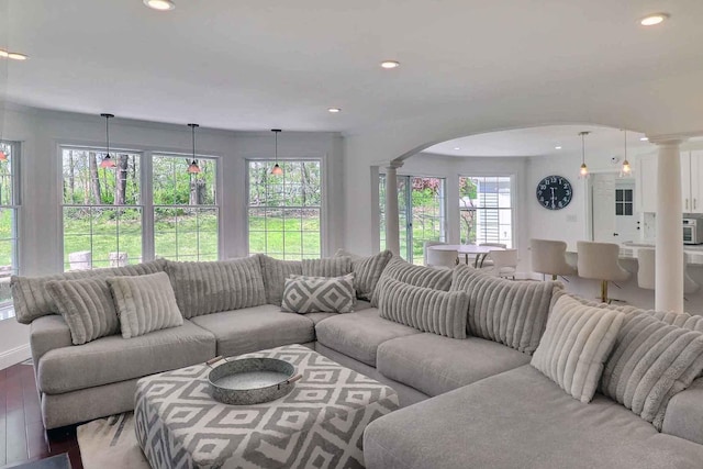 living area featuring ornate columns, arched walkways, plenty of natural light, and recessed lighting