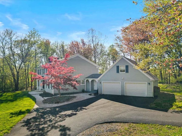 view of front of house with asphalt driveway and a front yard