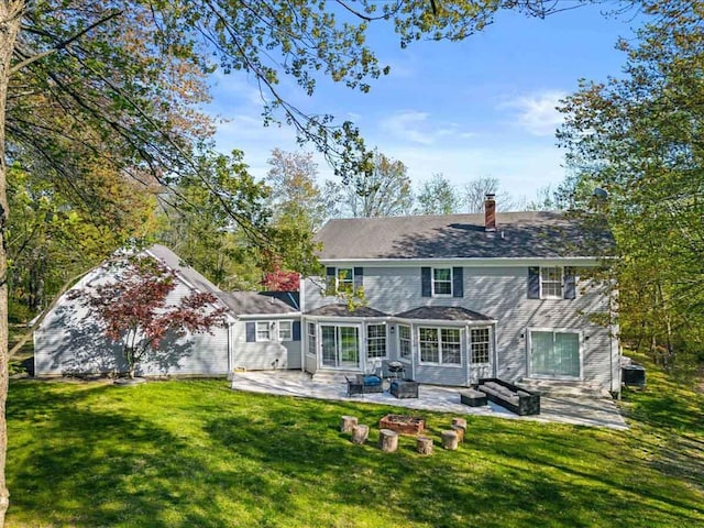 back of house featuring a patio area, a lawn, and a chimney