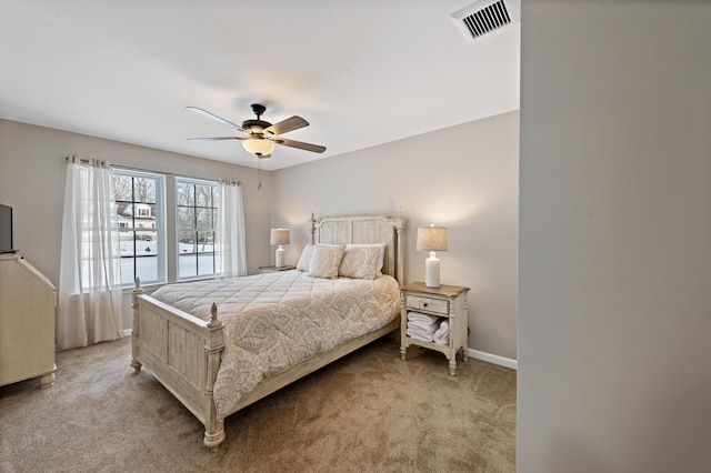 bedroom with a ceiling fan, light colored carpet, visible vents, and baseboards