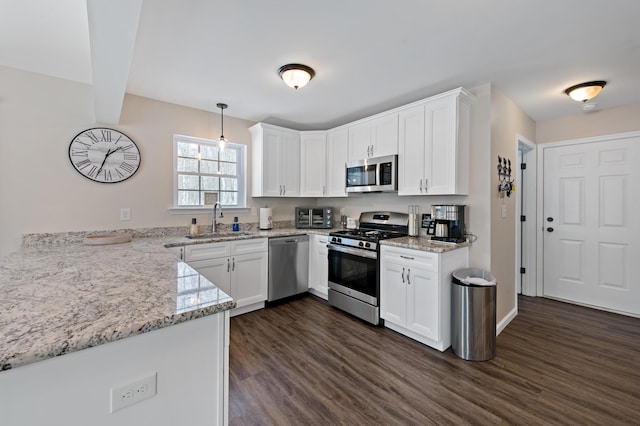 kitchen with white cabinetry, appliances with stainless steel finishes, dark wood-style flooring, and a sink