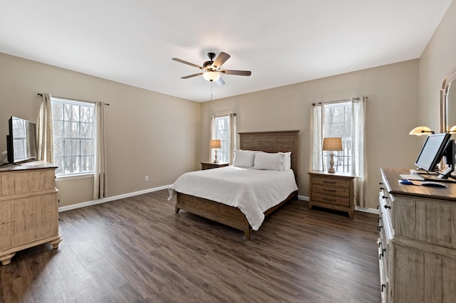 bedroom with multiple windows, dark wood finished floors, a ceiling fan, and baseboards