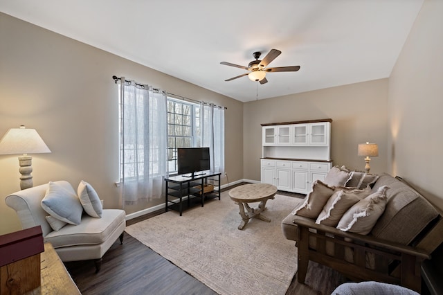 living area featuring ceiling fan, baseboards, and wood finished floors