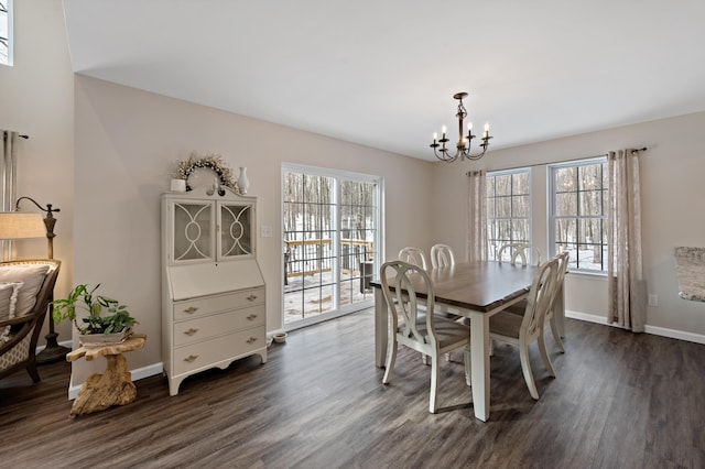 dining area featuring dark wood-type flooring, a healthy amount of sunlight, and a notable chandelier