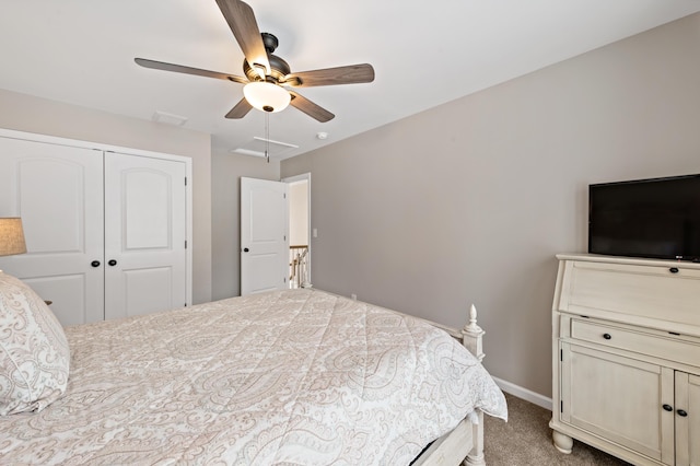 bedroom with carpet, a closet, attic access, a ceiling fan, and baseboards