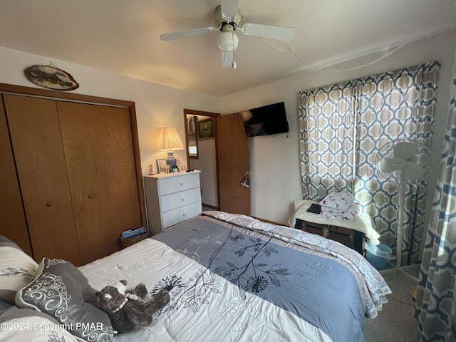 carpeted bedroom featuring ceiling fan and a closet