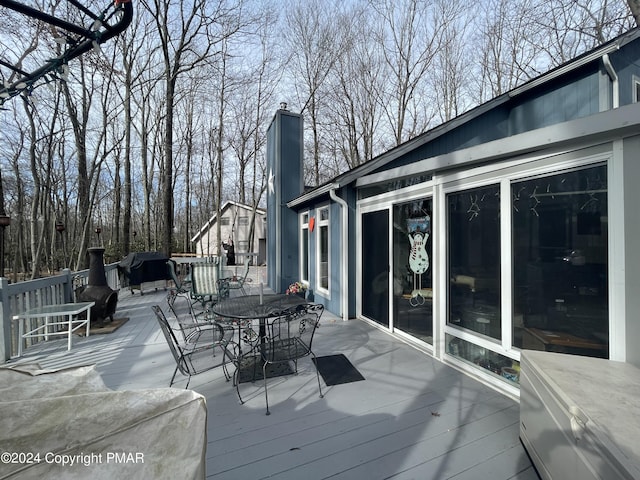 wooden terrace featuring a grill and outdoor dining area