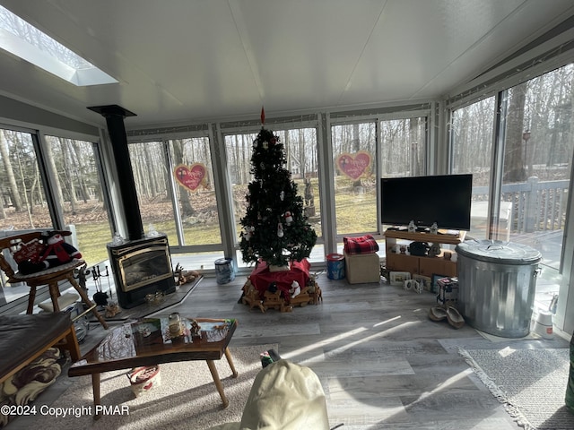 sunroom / solarium featuring a skylight and a wood stove