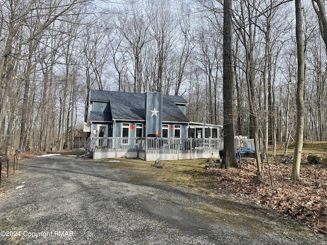 view of front of home with roof with shingles and a chimney