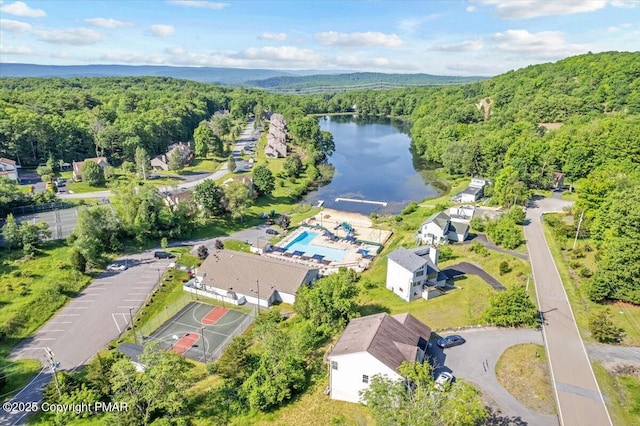 birds eye view of property with a water view and a view of trees