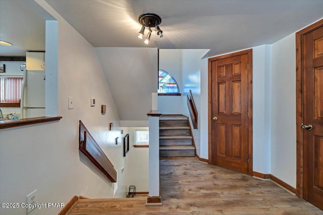 stairs featuring baseboards and wood finished floors