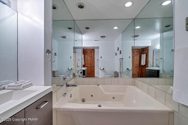 full bath with a whirlpool tub, toilet, vanity, and recessed lighting