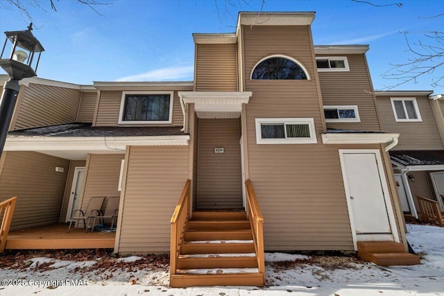 snow covered back of property with entry steps