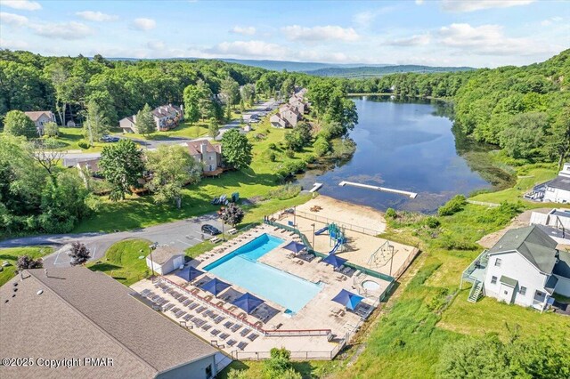 drone / aerial view with a water view and a wooded view