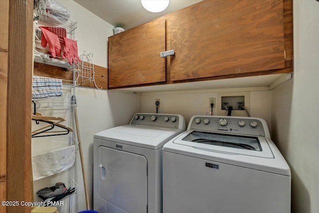 washroom featuring washer and clothes dryer and cabinet space