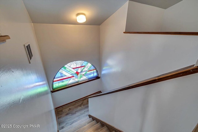 stairway with visible vents and wood finished floors