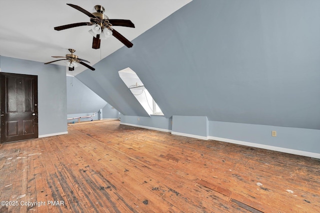 bonus room with vaulted ceiling with skylight, baseboards, ceiling fan, and hardwood / wood-style floors