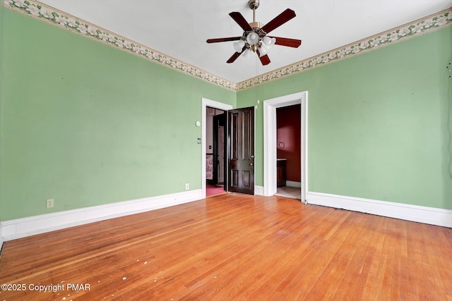 unfurnished room with ceiling fan, baseboards, and wood finished floors