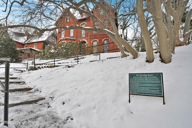 exterior space featuring fence and brick siding