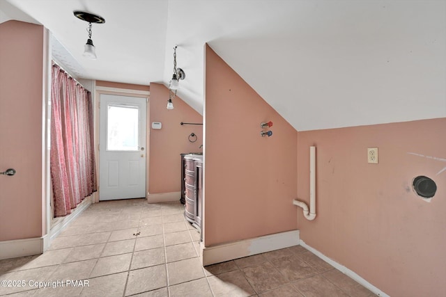 interior space with lofted ceiling, light tile patterned flooring, and baseboards