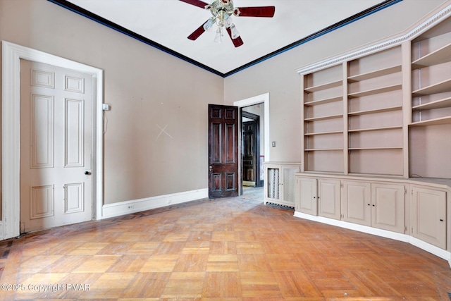 unfurnished living room with baseboards, ornamental molding, and a ceiling fan