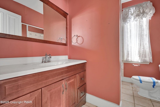 bathroom with baseboards, vanity, toilet, and tile patterned floors