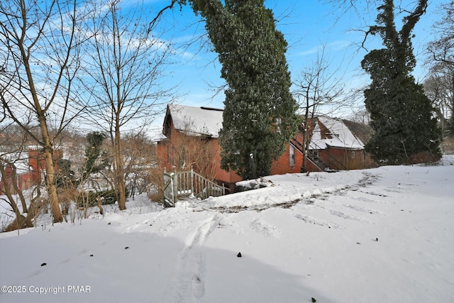 yard covered in snow featuring a detached garage