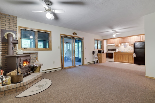 151 Forest Dr, Canadensis, PA 18325 - living room featuring a ceiling fan, a wood stove, a baseboard heating unit, and light carpet