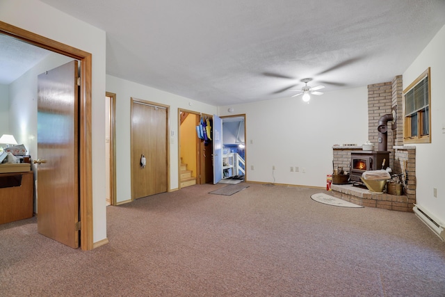 151 Forest Dr, Canadensis, PA 18325 - living area featuring ceiling fan, carpet, a wood stove, a baseboard radiator, and stairs