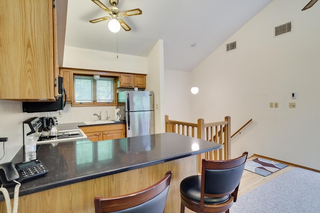 151 Forest Dr, Canadensis, PA 18325 - kitchen featuring freestanding refrigerator, a peninsula, a ceiling fan, vaulted ceiling, and wood finished floors