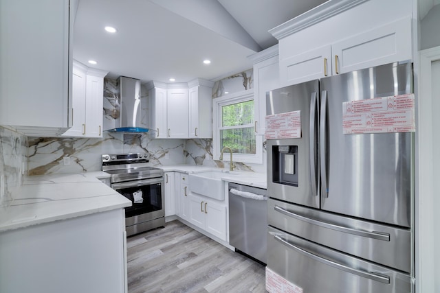 1005 Country Place Dr, Coolbaugh Township, PA 18466 - kitchen with appliances with stainless steel finishes, wall chimney exhaust hood, a sink, vaulted ceiling, and white cabinets