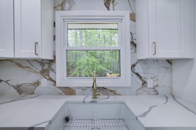 1005 Country Place Dr, Coolbaugh Township, PA 18466 - kitchen view of white cabinets, a sink, light stone countertops, and backsplash