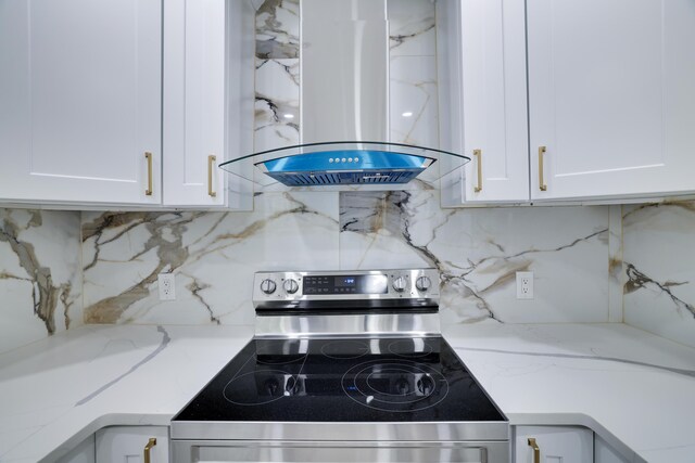 1005 Country Place Dr, Coolbaugh Township, PA 18466 - detailed view of stainless steel range with electric stovetop, island exhaust hood, white cabinets, and tasteful backsplash