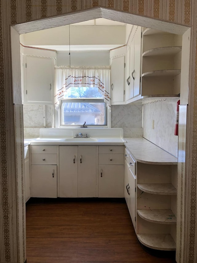 kitchen with white cabinetry, light countertops, dark wood-type flooring, and open shelves