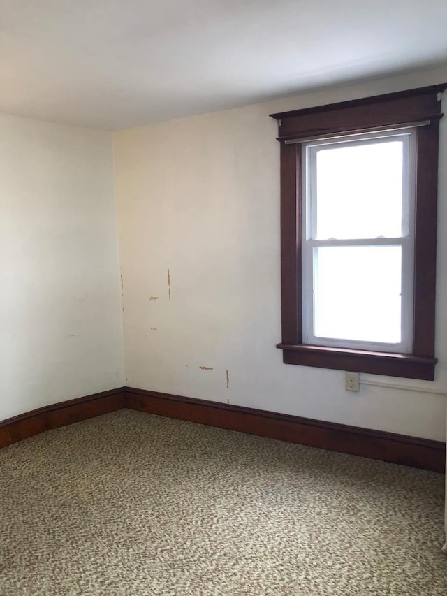 carpeted empty room with baseboards