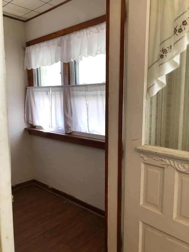 spare room featuring baseboards and wood finished floors