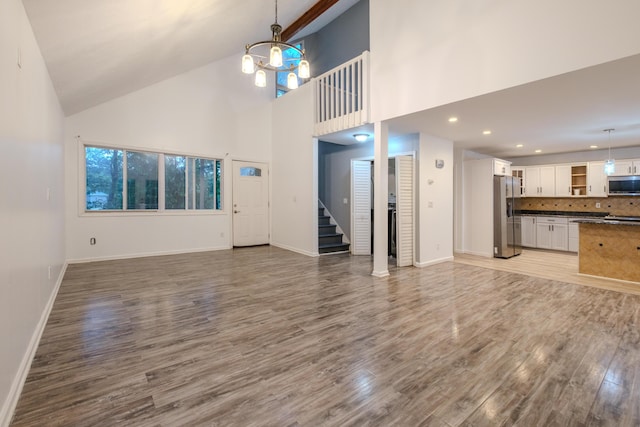 5104 Lake Dr, East Stroudsburg, PA 18301 - unfurnished living room with light wood-style flooring, stairway, a chandelier, high vaulted ceiling, and recessed lighting