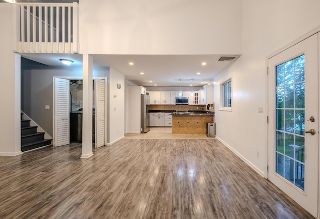 5104 Lake Dr, East Stroudsburg, PA 18301 - unfurnished living room with stairs, wood finished floors, a towering ceiling, and recessed lighting