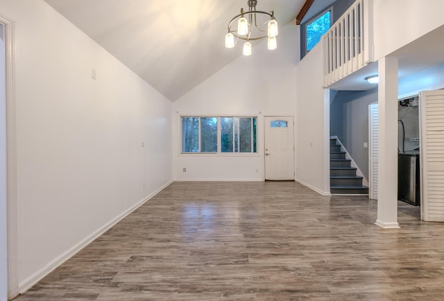 5104 Lake Dr, East Stroudsburg, PA 18301 - unfurnished living room with stairway, high vaulted ceiling, wood finished floors, and a chandelier