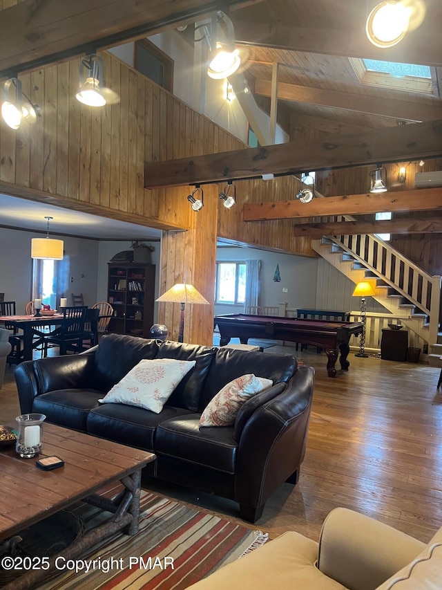 living room with high vaulted ceiling, hardwood / wood-style floors, wooden walls, and beam ceiling